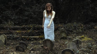 Женщина у могилы на кладбище