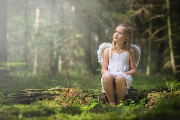 Девушка с ангельскими крыльями в лесу