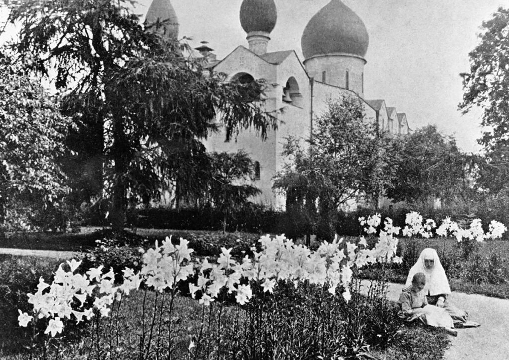 Монахиня из Марфо-Мариинской обители в саду со своим ребенком