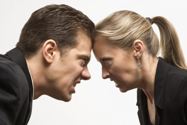Мужчина и женщина смотрят друг на друга с гневом