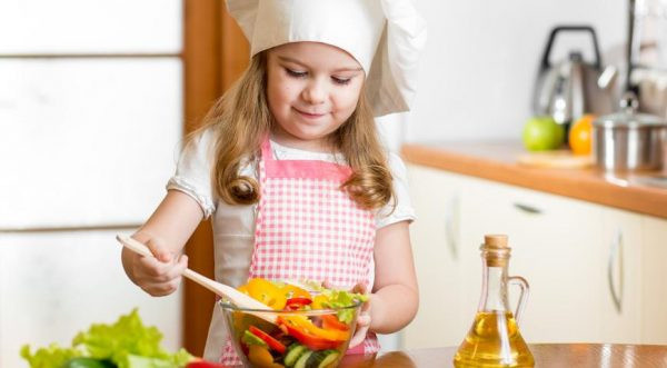 Маленькая девочка готовит салат