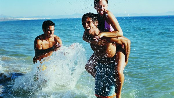Девушка и двое молодых людей плавают в море